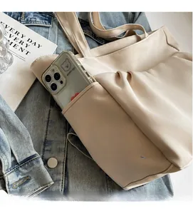 Detail view of the functional side pocket for smartphones on the off-white tote bag
