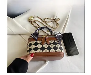 Size comparison of a quilted crossbody bag with silk scarf handle next to a smartphone
