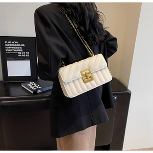Détail du sac bandoulière blanc matelassé avec chaîne dorée et fermoir métallique rétro