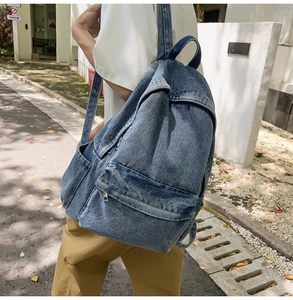 Detail view of a vintage wash denim backpack with durable zippers and casual style