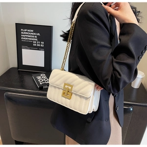 Détail latéral du sac bandoulière blanc matelassé en V avec boucle dorée et chaîne