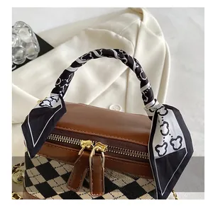 Detail of plaid handbag with brown leather handle and cute bear print silk scarf