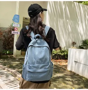 Detailed outdoor view of blue denim backpack with large main compartment and side pockets
