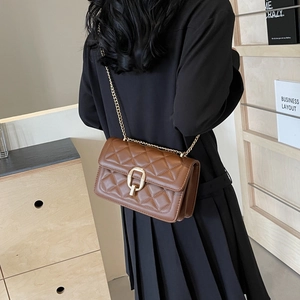 Detailed back view of a brown quilted leather crossbody bag with a golden chain strap