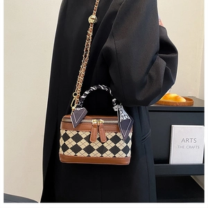 Detail of checkered mini trunk bag with gold chain strap and silk scarf handle decor
