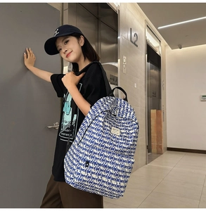 Detail of white canvas backpack featuring repetitive blue love of god letter print