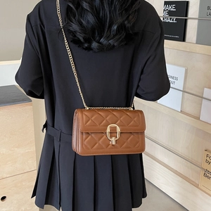 Brown quilted crossbody bag with gold chain strap shown in an elegant lifestyle setting