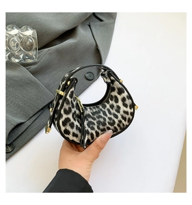 Close-up of leopard print crescent bag with premium gold hardware and zipper