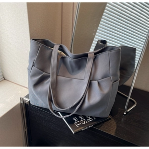 Detailed view of grey canvas tote bag featuring functional multi-pocket design for storage