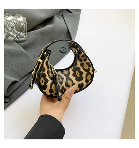 Detailed view of mini crescent leopard print handbag with golden metal hardware