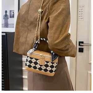 Chic quilted mini trunk bag with silk-wrapped handle and leather chain strap on model