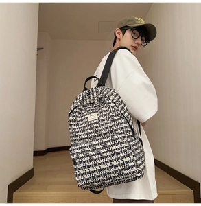 Detail view of large capacity canvas backpack with 'love of god' all-over text print