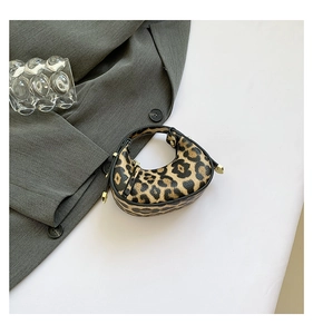 Detailed side view of leopard print crescent mini handbag with premium gold hardware