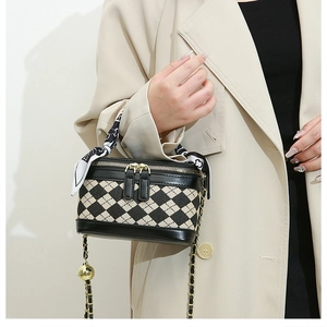 Detail of checkered crossbody bag with silk scarf handle and gold chain strap