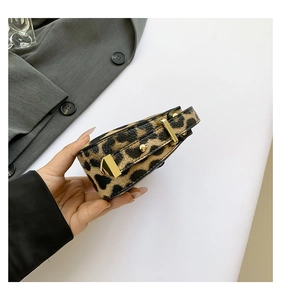 Close-up of leopard print handbag showing grainy leather texture and gold hardware details