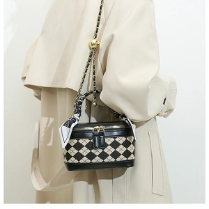 Detail of a luxury quilted mini bag with gold chain strap and decorative silk scarf