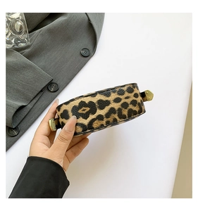 Detailed side view of leopard print crescent handbag with golden metal buckles