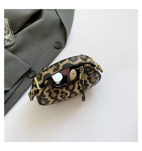 Close-up of leopard print mini bag showing spacious interior with lipstick and gold zipper