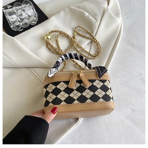 Detail of the chain crossbody bag with woven plaid pattern and silk scarf handle