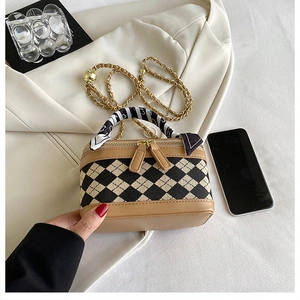 Close-up of quilted crossbody bag with silk scarf handle and gold chain strap detail