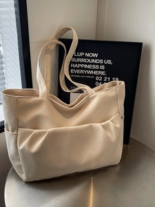 Minimalist beige faux leather tote bag with large pleated pocket for daily commute