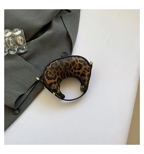 Detail of leopard print crescent bag with leather texture and golden metal buckle