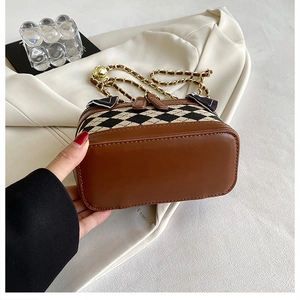 Close-up of quilted pattern crossbody bag with chain strap and silk scarf bow detail