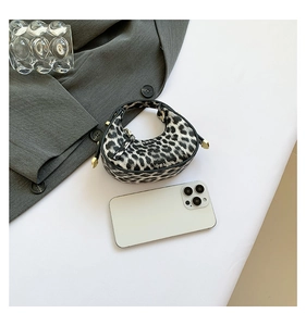 Top view of mini leopard print crescent bag with smartphone for size comparison