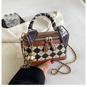 Close-up of diamond lattice handbag with silk scarf handle and gold chain strap