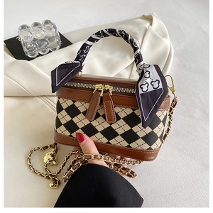 Detailed close-up of a checkered crossbody bag with silk scarf handle and gold chain strap