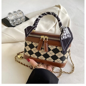 Close-up of quilted chain bag with silk scarf handle and dual zipper details