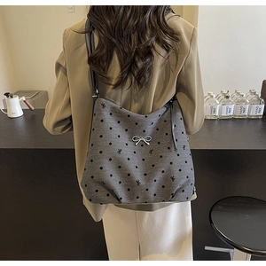 Détail du grand sac cabas gris avec motifs à pois noirs et boucle en forme de nœud argenté
