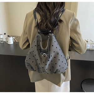 Détail du sac à dos gris à pois avec nœud métallique et bretelles en cuir brillant