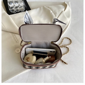 Interior view of quilted crossbody bag showing smartphone and makeup storage capacity