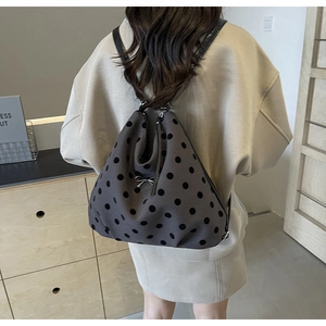 Vue arrière du modèle portant un sac à dos gris à pois avec détail de nœud en argent