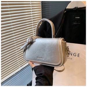 Close-up of silver matte leather handbag with metallic finish and top handle