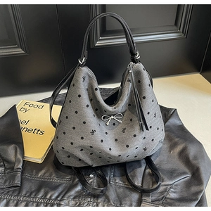 Détail du sac gris à pois avec broderie nœud et lanières en cuir verni noir