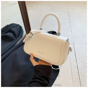 Detail of white matte leather handbag featuring cylindrical handle and Shiyu-Bag logo