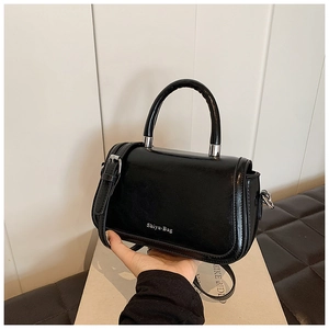 Detail of glossy black leather handbag with silver hardware and Shiyu Bag logo