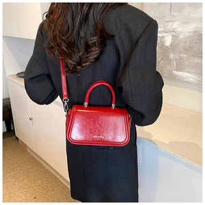 Close-up of a red shiny crossbody bag with silver hardware and Shiyu Bag logo lettering