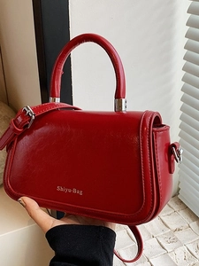 Dark red glossy leather crossbody handbag with sturdy handles and adjustable strap