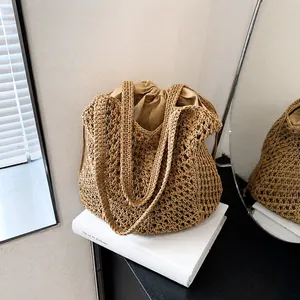 Detail of hand-woven beige tote bag showing mesh texture and drawstring inner pouch