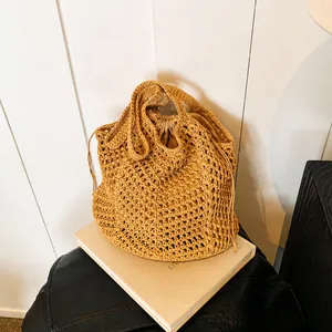 Detailed view of woven straw bucket bag with drawstring liner and textured mesh pattern