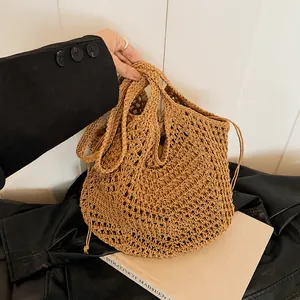 Detail of hand-woven crochet bucket bag with hollow mesh texture and drawstring closure