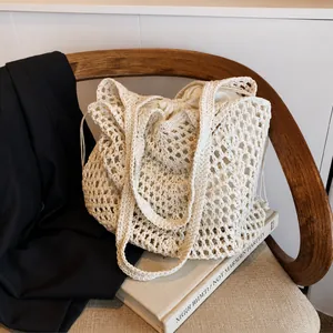 Detail of hollow woven cotton tote bag with drawstring inner pouch on a wooden chair