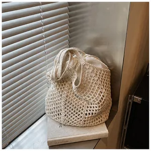 Close-up of beige crochet tote bag with hollow knit mesh and drawstring inner liner