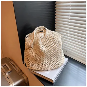 Macro detail of creamy white woven cotton bucket bag with mesh knit pattern and drawstring liner