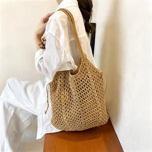 Detail of hollow-out woven straw tote bag with drawstring closure for beach holiday