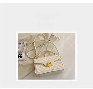 Détail du sac bandoulière matelassé crème avec serrure à rivets dorés et similicuir