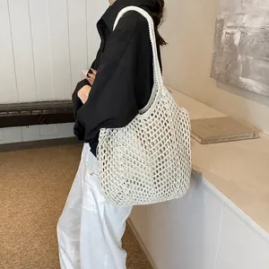 Detail of white cotton rope woven tote bag with hollow mesh design for beach use